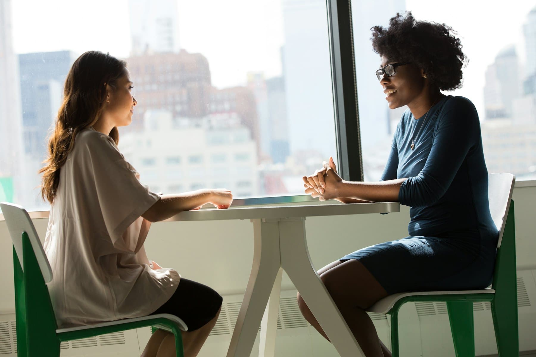 A support coordinator and participant talking at a table in a bright office