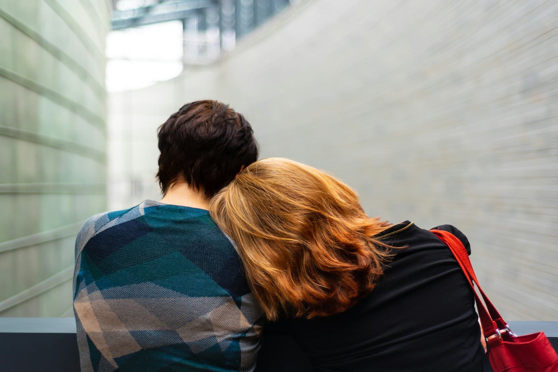 A person resting their head on a friend’s shoulder for comfort