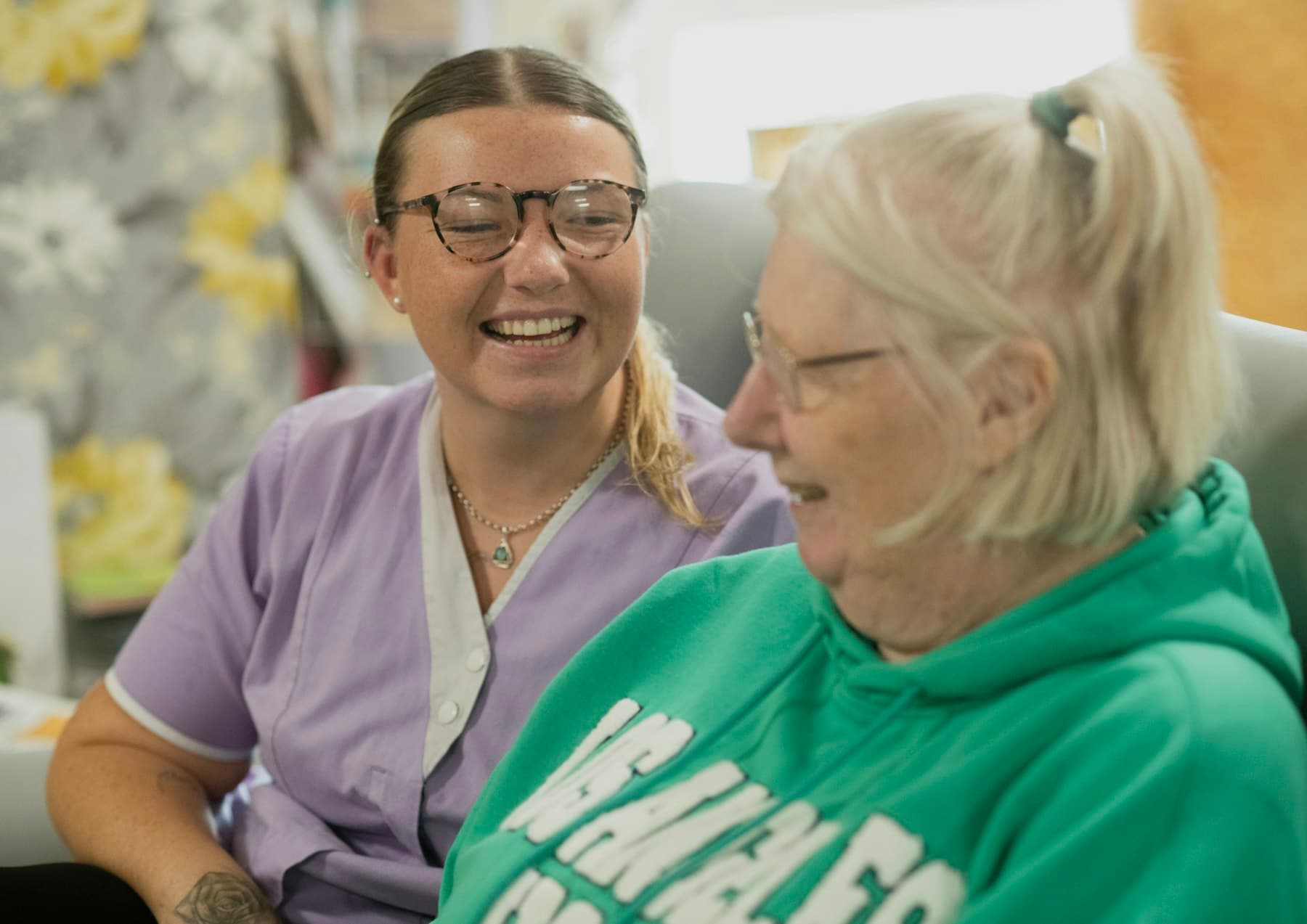 A support worker and an older woman sharing a laugh